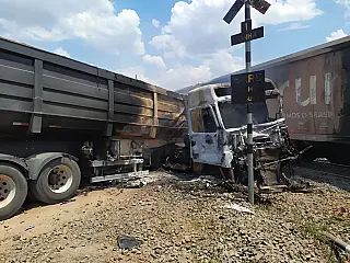 Carreta colide com trem, pega fogo e motorista fica ferido