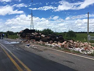 Caminhão tomba na curva com 11 mil pacotes de cigarros e motorista morre