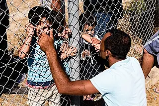 Após um ano sem ver a família refugiado sírio beija filhos em reencontro separado por cerca