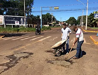 Iniciativa popular tapa buracos com concreto em via pública