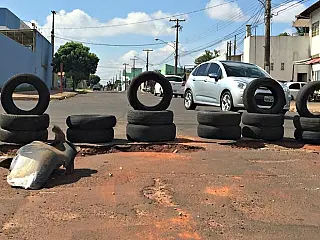 Pneus sinalizam buraco em frente à borracharia na Capital