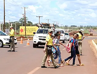 Agentes de trânsito fazem a travessia de estudantes em rodovia do Estado